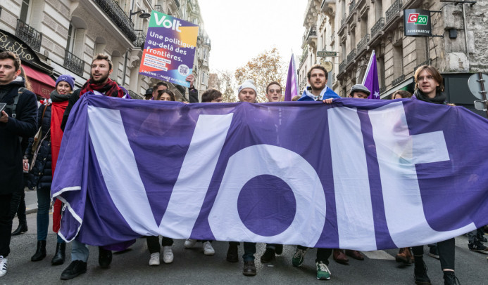 Členovia strany Volt na pochode vo Francúzsku držiaci veľkú zástavu s logom Volt - prvej a jedinej paneurópskej politickej strany